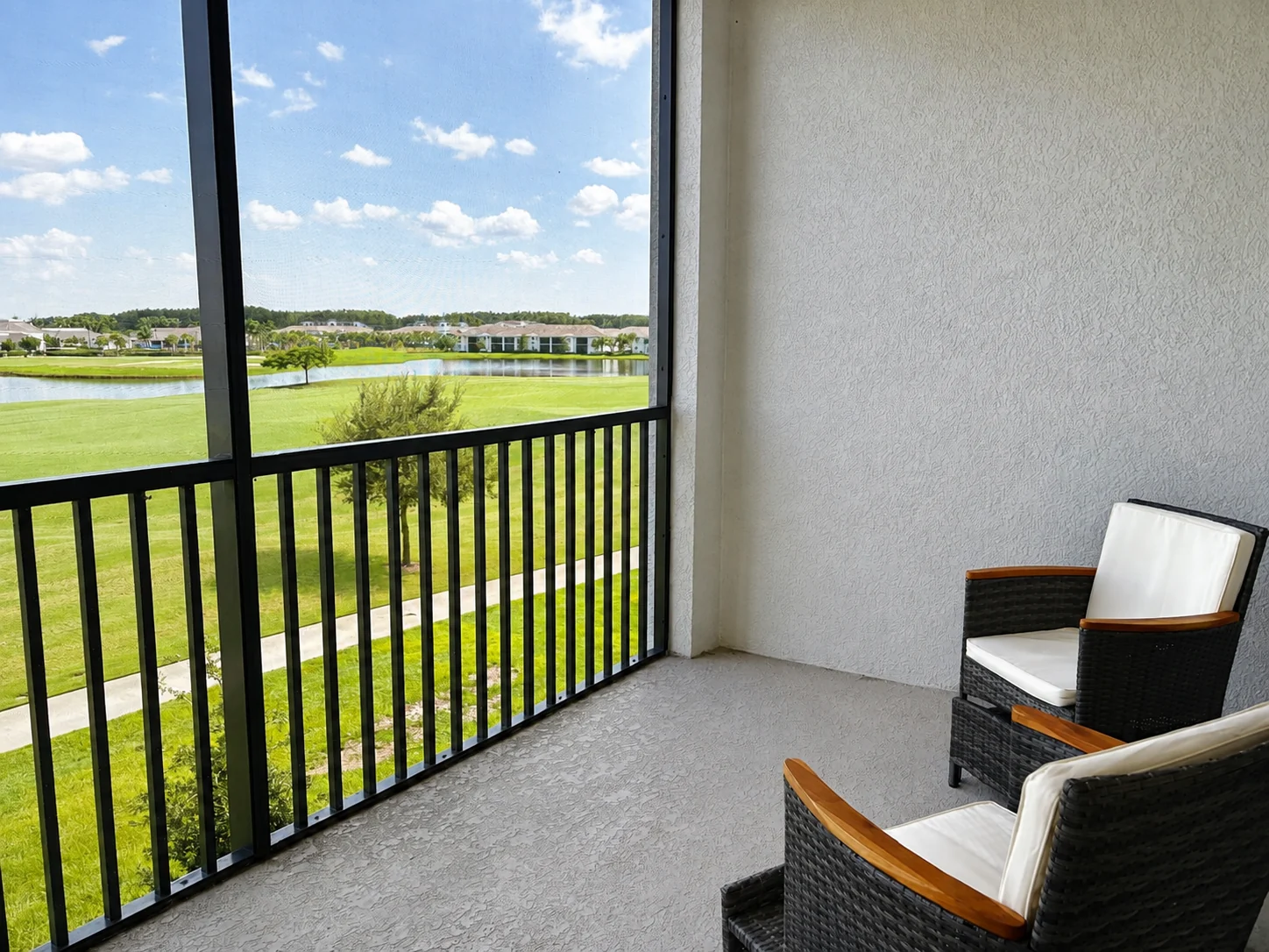 Screened terrace overlooking the water and landscaped grounds at the Ave Maria Residence